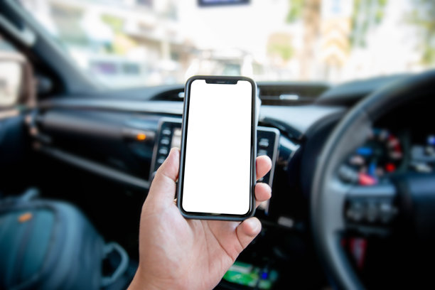一张特写照片，展示一名男子在使用智能手机。汽车内的智能手机白屏模型，用于展示您的图形横幅。图片下载