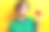 穿着绿色衬衫、可爱甜美的小女孩在黄色背景下展示小红心的照片图片下载