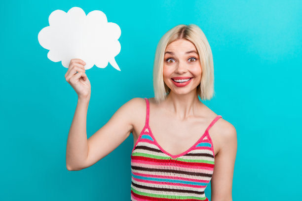 漂亮年轻女孩的照片肖像，兴奋而震惊地手持纸云，穿着时尚的条纹服装，背景为水绿色。图片下载