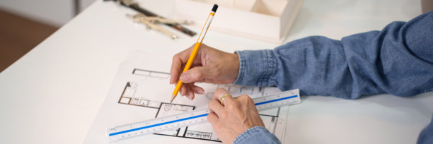 建筑师用铅笔和尺子手绘房屋施工设计蓝图，成年建筑师正在制作蓝图，建筑师绘制建筑计划图片下载