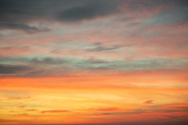 美丽的日落景观，奢华柔和的渐变橙金色云彩和阳光映照在蓝色戏剧性的天空上，完美适合作为背景，早晨、傍晚、黄昏，气候变化，横向日落照片图片下载