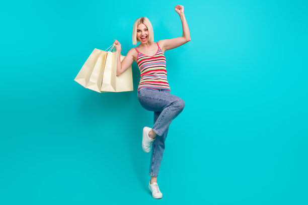 穿着条纹背心的可爱幸运女孩举起拳头，背景为青色，整张照片呈现全身。图片下载