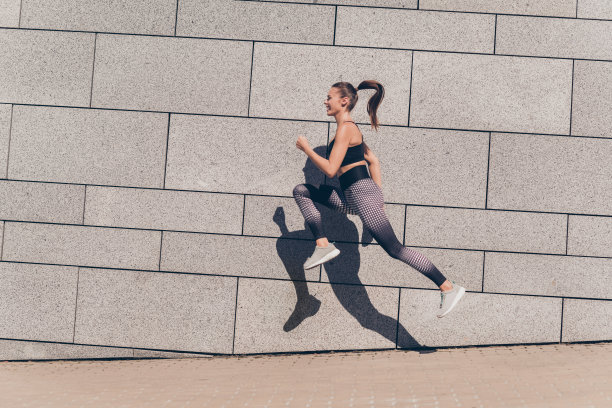 运动教练女士在市中心比赛跑步前的侧面个人资料照片，背景是户外健身建筑。图片下载