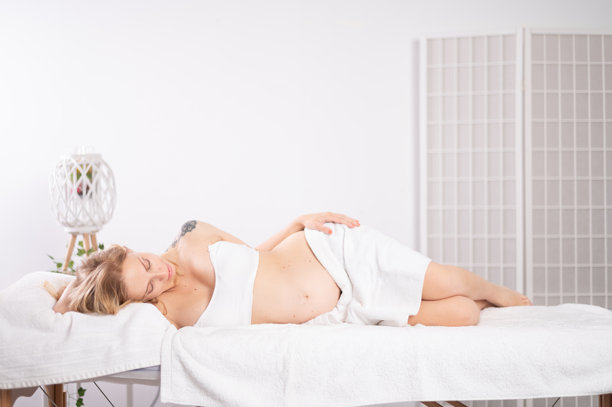 孕妇在水疗中心的按摩台上放松图片下载