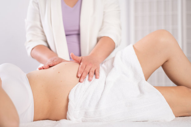 按摩师为孕妇的肚子进行产前按摩图片下载