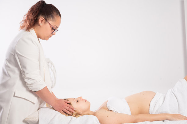 按摩师为孕妇进行头部按摩图片下载