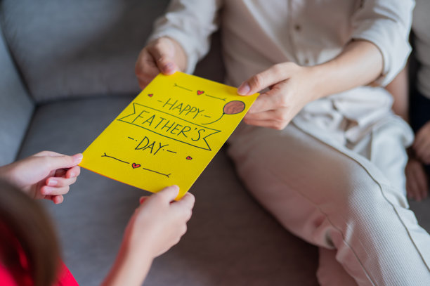 女儿近距离递交自制父亲节卡片的照片图片下载