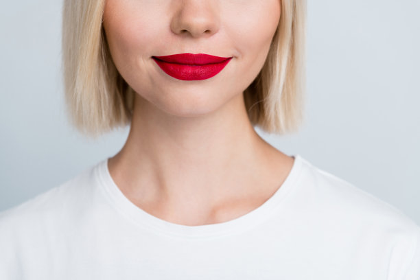 特写裁剪照片，展示魅力女孩的红色诱人性感嘴唇，注射了肉毒杆菌，背景为灰色。图片下载