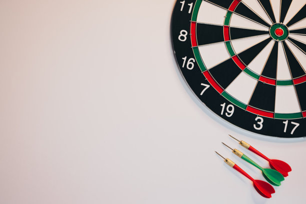 商业目标概念。白色背景上的飞镖和飞镖盘，适用于游戏、运动、家庭娱乐和休闲活动。图片下载