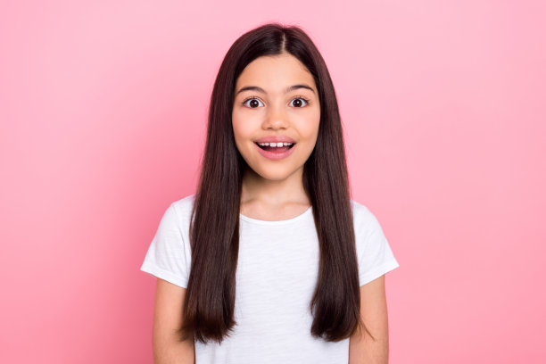 穿着时尚白色衣服的小女孩，面露震惊表情的照片肖像，背景为粉色。图片下载