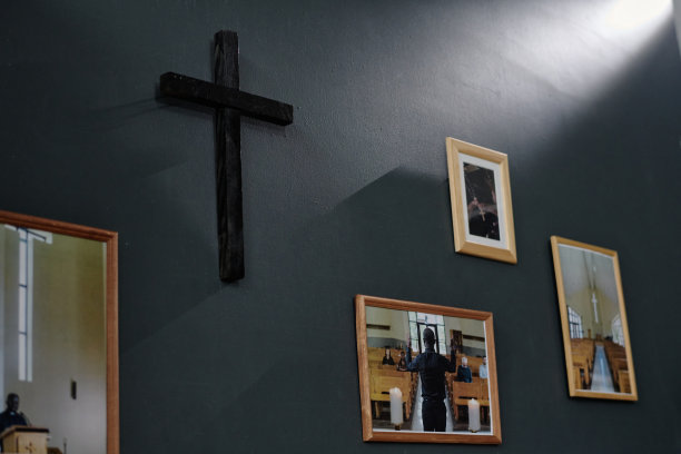 黑色十字架和深灰色墙上的相框照片图片下载