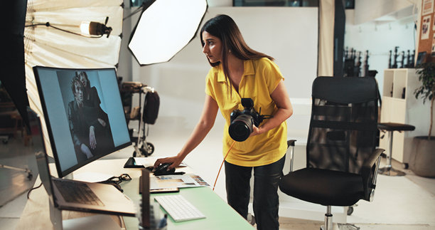 编辑、摄影师和拿着相机的女性，电脑和创意用于工作室或严肃项目。商业、艺术家和使用技术进行摄影、后期制作和图片选择的人。图片下载