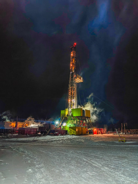 在雪地环境中夜间工作的照明石油钻井平台。采矿。手机照片图片下载