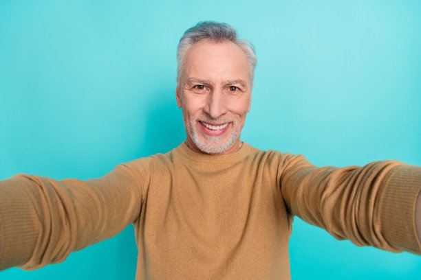 快乐帅气的爷爷在蓝绿色背景下环游世界自拍特写照片图片下载