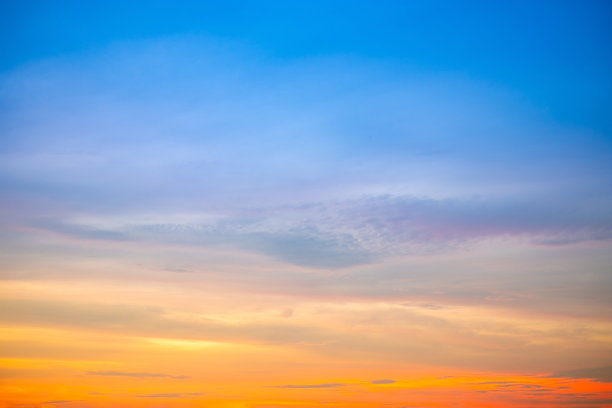 美丽的日落景观，奢华柔和的渐变橙金色云彩和阳光映照在蓝色戏剧性的天空上，完美适合作为背景，早晨、傍晚、黄昏，气候变化，横向日落照片图片下载