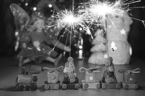 用塑料泥制作的玩具火车和燃烧的烟花。黑白照片。图片下载