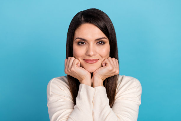 年轻可爱的女孩在蓝色背景下进行梦幻般的皮肤护理提升美容程序的照片图片下载