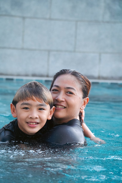 母亲和儿子在游泳池里玩耍的照片图片下载