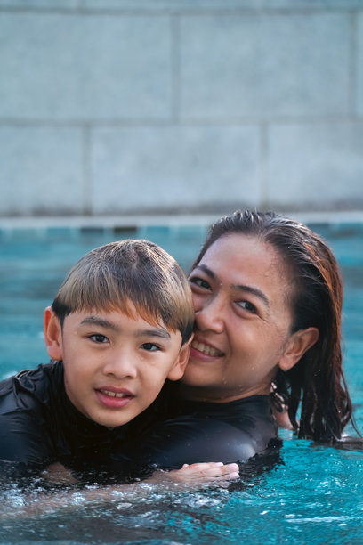 母亲和儿子在游泳池里玩耍的照片图片下载