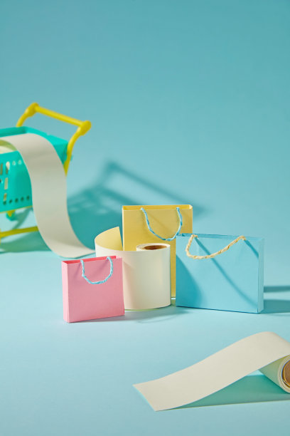 可爱的纸质购物袋和迷你账单卷在蓝色背景上，表达了在线购物的紧迫感和限时优惠。创意摄影与购物概念相结合。图片下载