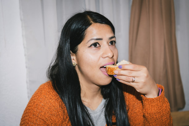 用户生成内容。个人档案照片。由真实人物拍摄的复古风格照片。女人吃面包配鹰嘴豆泥。图片下载