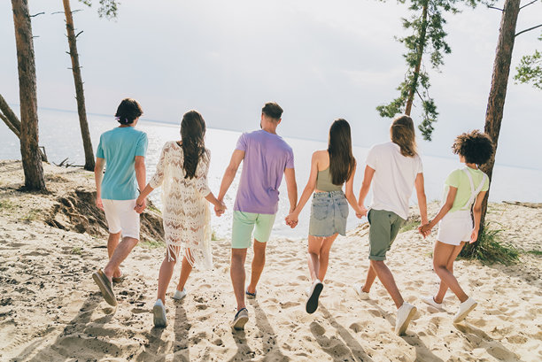 积极的人们在海岸线外相聚，手牵手，享受休闲时光的背面脊柱照片图片下载