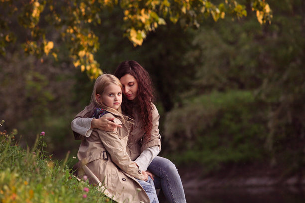 母亲与女儿在公园草地上共度时光的生活照片。图片下载