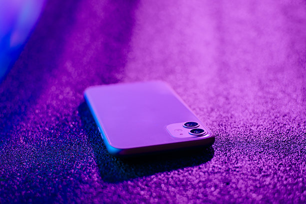 带修理工具的手机照片。紫色和蓝色背景。白色手机配有两个摄像头。图片下载