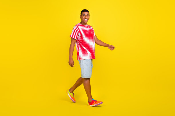 男孩与女友约会的全身侧面照片，背景为明亮的黄色。图片下载