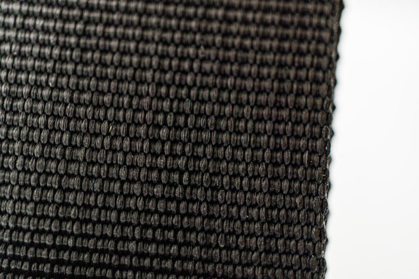 这张图片特写展示了一种高质量的深色面料，具有复杂的图案，突显其奢华的质感和耐用性。简单的白色背景衬托出面料独特的设计。图片下载