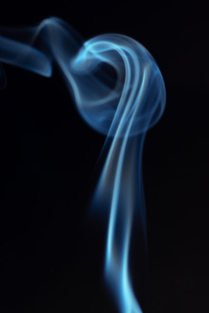 细腻的蓝色烟雾在黑暗背景上优雅地旋转，形成一种抽象而飘渺的视觉效果，展现流动的动感。神秘与创造力的概念。旋转、扭动的烟雾可用于叠加在您的照片上。图片下载