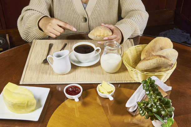 早餐概念。特写照片展示一位女性在厨房享用早餐。图片下载