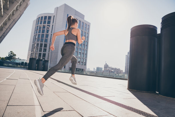 肌肉发达的女教练在户外准备短跑比赛的背部脊柱视角照片图片下载