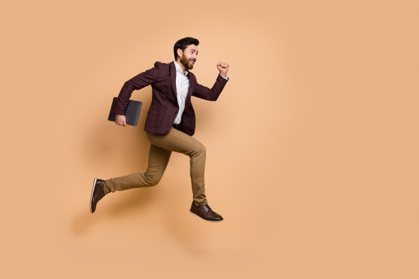 疯狂商人匆忙赶往工作会议的全身侧面照片，背景为米色。图片下载