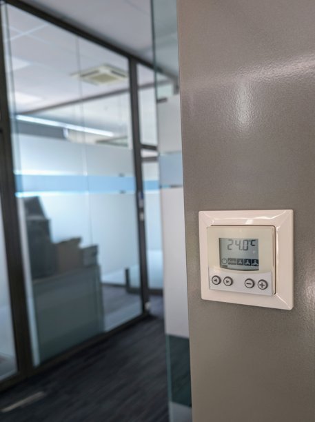 现代办公室墙壁上的数字气候控制恒温器特写照片，显示温度为24摄氏度图片下载