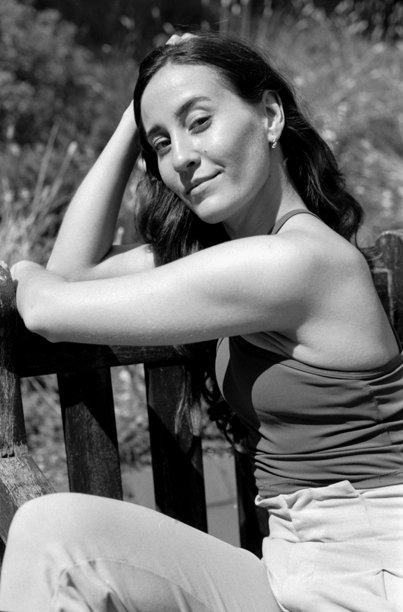 年轻女性在花园的长椅上放松，颗粒感的胶卷照片图片下载