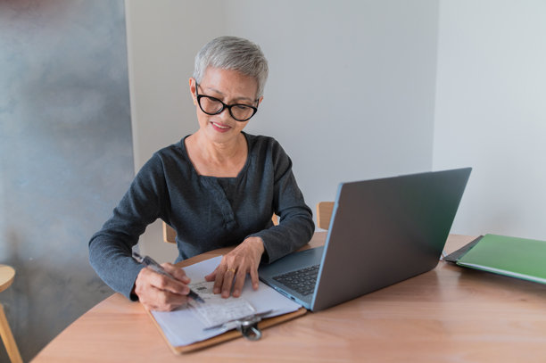 在家工作的亚洲华裔老年女性查看每月开支预算的照片图片下载