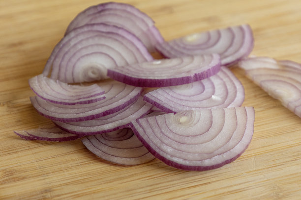 红洋葱切片特写照片，放在木板上图片下载