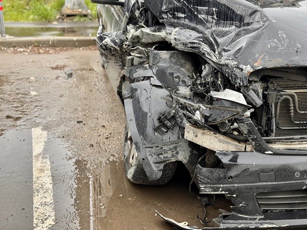 这张图片展示了一辆汽车的特写，前部严重受损，显示出最近一起碰撞和交通事故造成的广泛损坏。图片下载