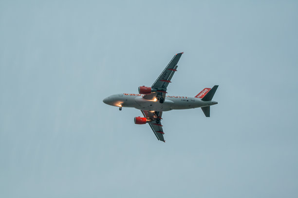 日落时分从下方拍摄的飞机降落照片图片下载