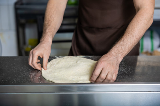 厨师正在处理比萨面团的特写照片图片下载