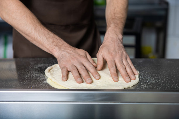 厨师正在处理比萨面团的特写照片图片下载
