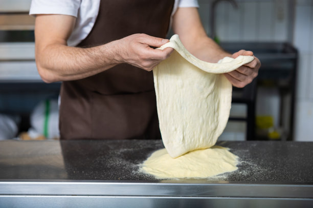 厨师正在处理比萨面团的特写照片图片下载