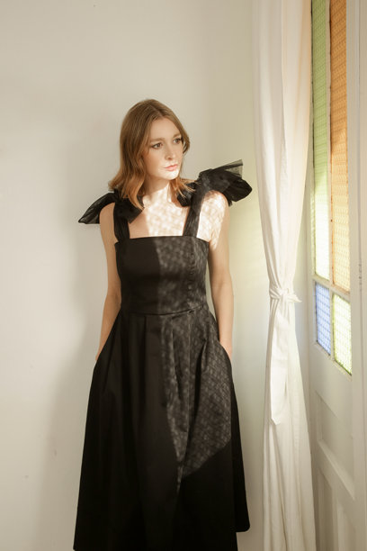 一系列穿着优雅黑色中长裙、肩带上带有蝴蝶结的女性模特照片图片下载