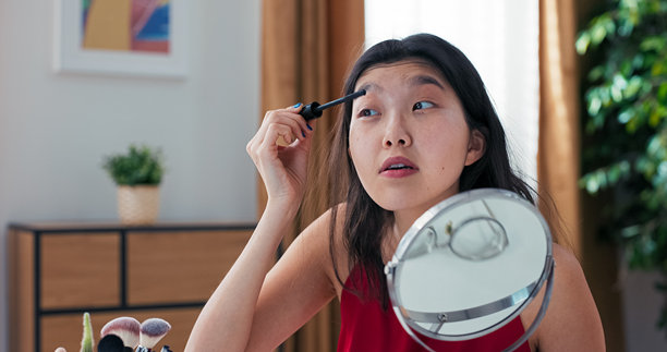 一位美妆博主录制视频，评测与合作品牌的睫毛膏。她在涂抹产品的同时分享正确的使用技巧。图片下载