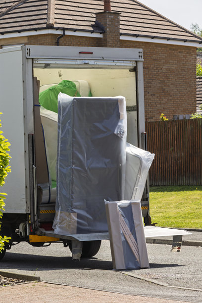 一辆送货卡车在郊区住宅卸下一张新的塑料包装床。这张图片唤起了搬家日、新开始、电子商务和家庭送货服务的主题。图片下载