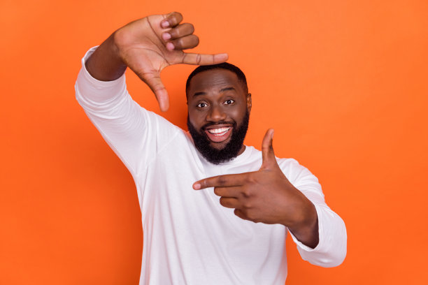 穿着白色毛衣的搞笑可爱男孩展示手臂的照片，背景为橙色。图片下载