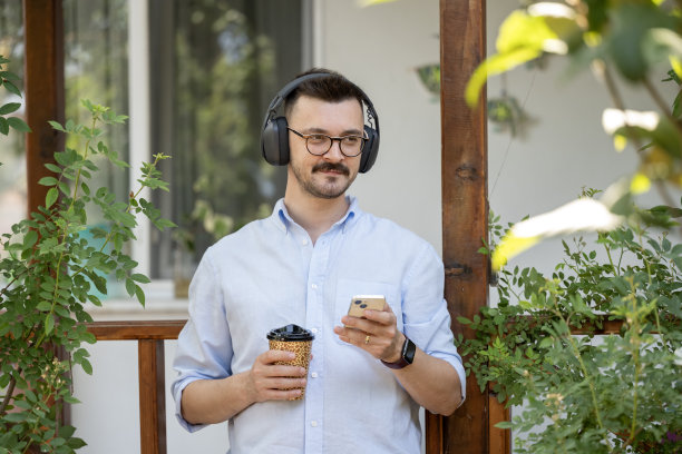 这张照片展示了一名男子在公寓阳台上享受宁静时光。图片下载
