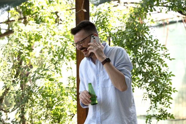 这张照片展示了一名男子在公寓阳台上享受宁静时光。图片下载