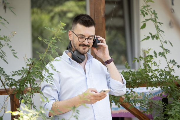 这张照片展示了一名男子在公寓阳台上享受宁静时光。图片下载